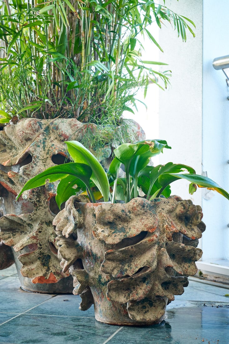 Four terracotta 'Acanthus' planters, French, (4): Four terracotta 'Acanthus' planters, French, hand-built with applied leaf decoration, with chips and losses to the decoration and patina, height of planter: 45.0cm, diameter of planter top:
