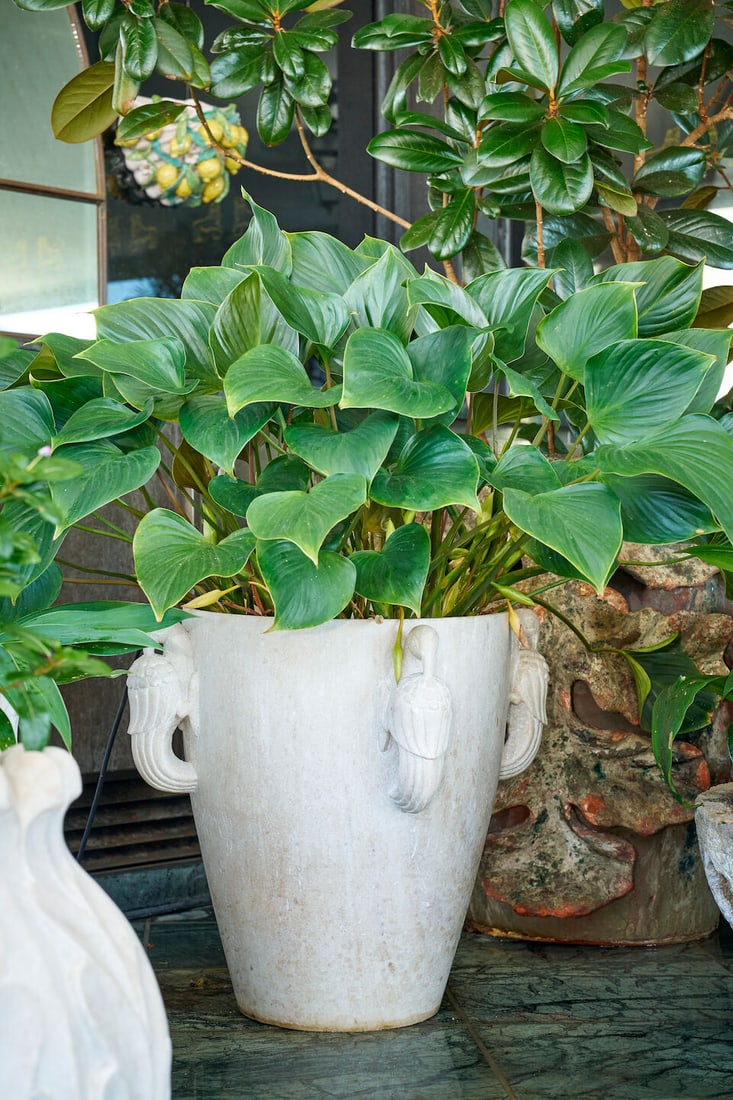 A white marble vase form planter,: A white marble vase form planter, with four handles in the form of birds, height of planter: 51.0cm, diameter of planter top: 41.0cm This lot is subject to the following lot symbols: W TP W Please