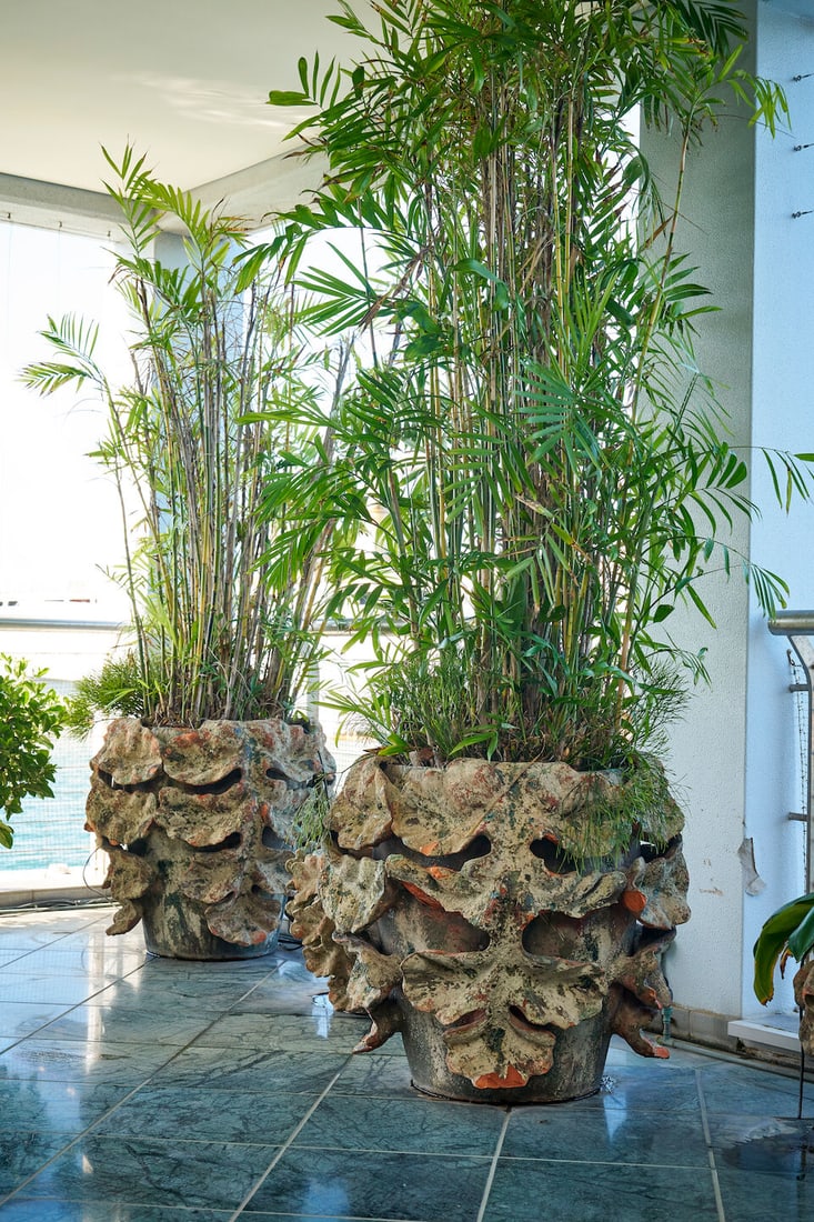 A pair of large terracotta 'Acanthus' planters, French, (2): A pair of large terracotta 'Acanthus' planters, French, hand-built with applied leaf decoration, both planted with bamboo, height of planter: 73.0cm, diameter of planter top: 70.0cm (2) This lot is