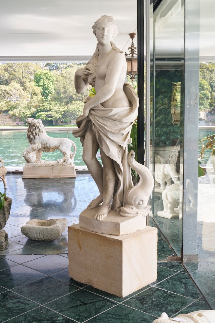 A Neoclassical style statue of Venus Marina,: A Neoclassical style statue of Venus Marina, in white marble, with losses, height: 170.0cm This lot is subject to the following lot symbols: W TP W Please note that this lot requires a heavy lift tran