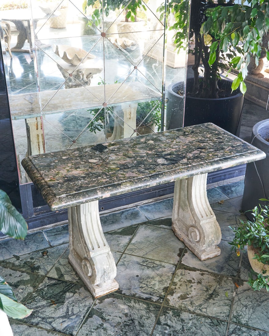 A garden console with Verde Marinace granite top,: A garden console with Verde Marinace granite top, supported by neoclassical pedestals in weathered composite stone, height: 80.0cm, width: 148.0cm, depth: 59.0cm This lot is subject to the following
