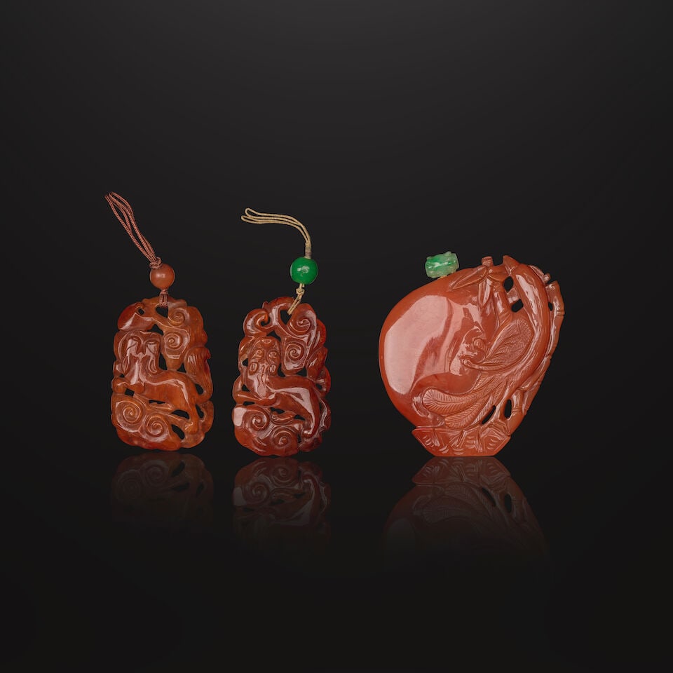 DEUX PENDENTIFS ET UNE TABATIÈRE EN CORNALINE SCULPTÉE Fin de la Dynastie Qing (1644-1... (1 of 2)