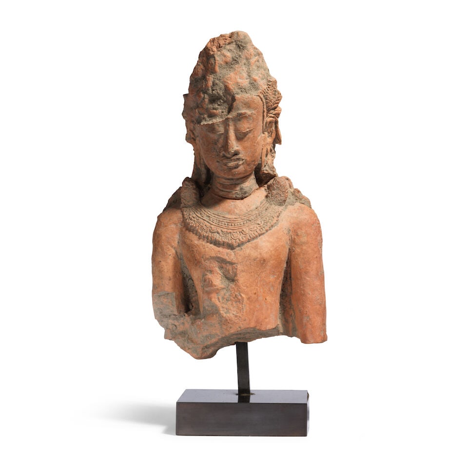 BUSTE DE BOUDDHA COURONNÉ EN TERRE CUITE Thaïlande, Haripunjaya, XIIIe siècle (2): BUSTE DE BOUDDHA COURONNÉ EN TERRE CUITE Thaïlande, Haripunjaya, XIIIe siècle A TERRACOTTA BUST OF A CROWNED BUDDHA Thailand, Haripunjaya, 13th century Stand 25.5 cm (10 in.) high (2). 