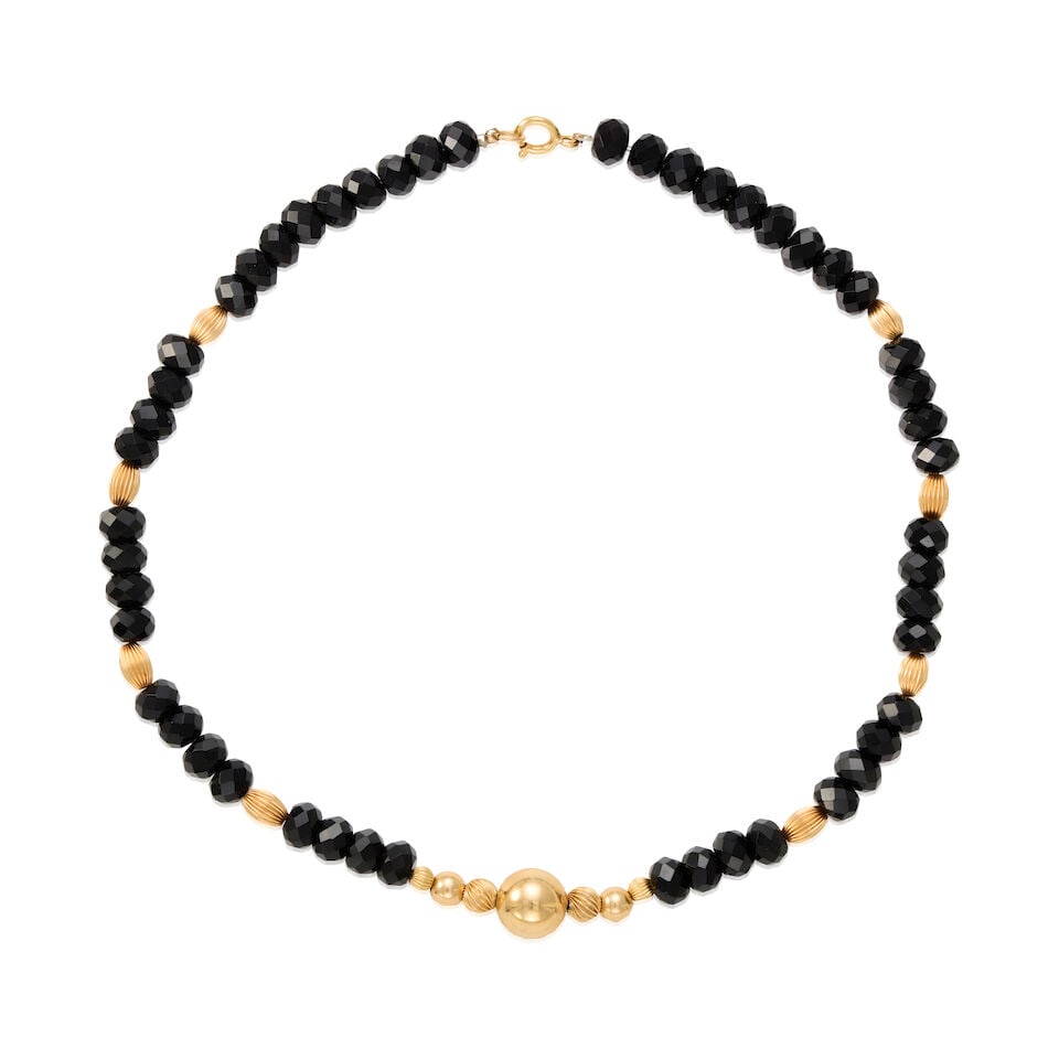GOLD AND ONYX NECKLACE: GOLD AND ONYX NECKLACE • 14K yellow gold beads • Numerous carved onyxes measuring approximately 9.48mm in diameter • Length 18 in. • Estimated gross weight: 48.2 grams Footnote