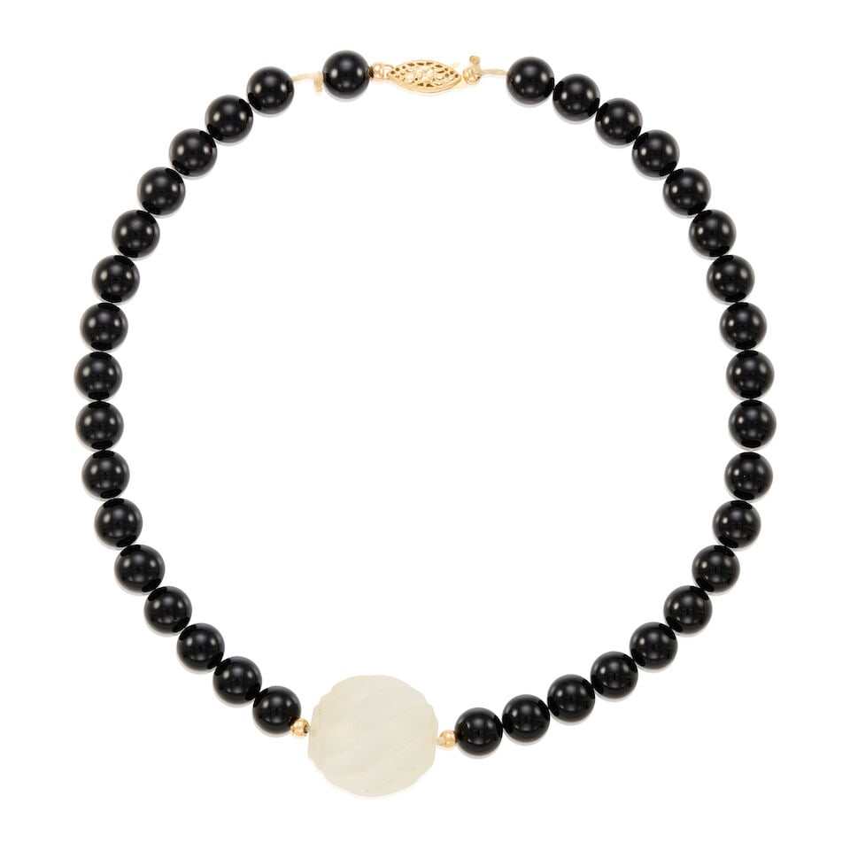 14K GOLD, ROCK CRYSTAL, AND ONYX NECKLACE: 14K GOLD, ROCK CRYSTAL, AND ONYX NECKLACE • 14K yellow gold • One carved rock crystal measuring approximately 23.26mm x 24.01mm • Numerous round shaped onyxes measuring