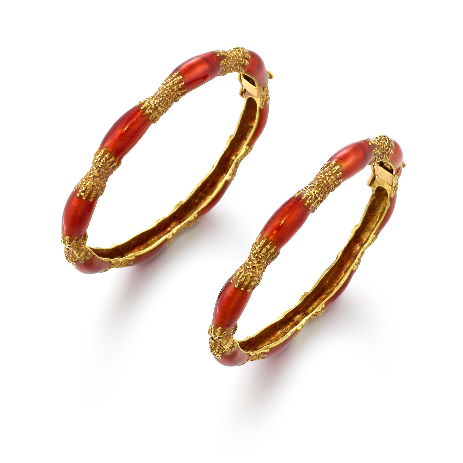 A SET OF 14K GOLD AND ENAMEL BRACELETS: A SET OF 14K GOLD AND ENAMEL BRACELETS Both hinged bangles, accented with orange enamelwork; with maker's mark; inner circumferences 6 1/4 in.; widths 1/4 in. Footnotes: OVERALL CONDITION: Metal stamp