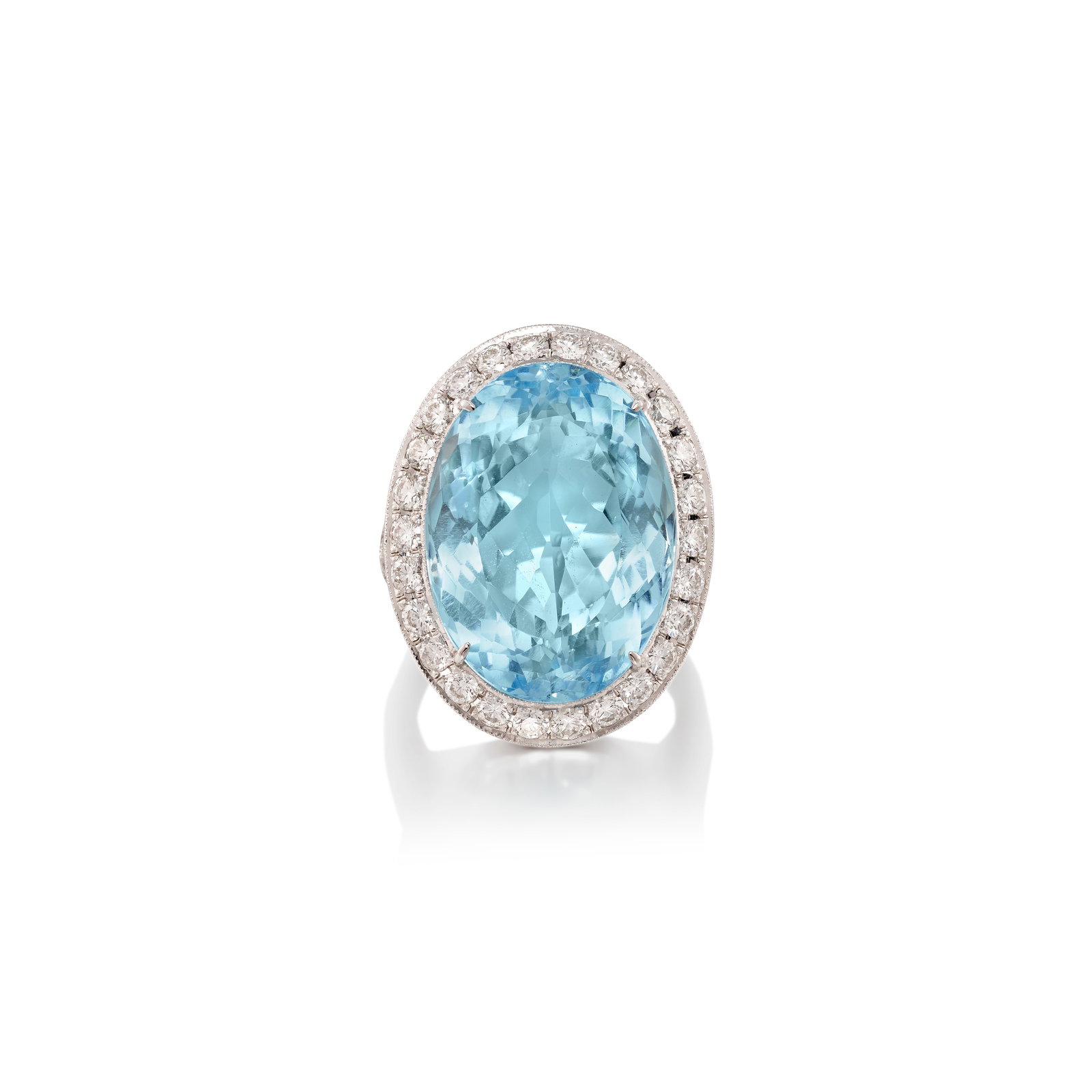 AN 18K WHITE GOLD, TOPAZ AND DIAMOND RING: AN 18K WHITE GOLD, TOPAZ AND DIAMOND RING Centering an oval-shaped topaz, accented with round brilliant-cut diamonds, with engraved detailing; estimated total topaz weight 31.00 carats; estimated