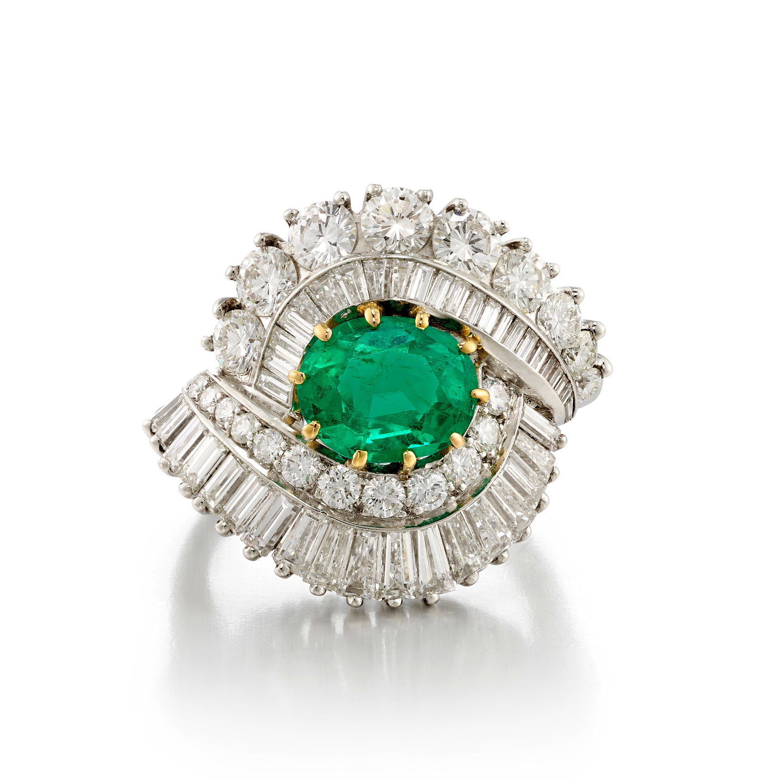 A PLATINUM, 18K GOLD, EMERALD AND DIAMOND RING: A PLATINUM, 18K GOLD, EMERALD AND DIAMOND RING Centering an oval-shaped, mixed-cut emerald, weighing 1.57 carats, in a surround of round brilliant and baguette-cut diamonds; with maker's mark;