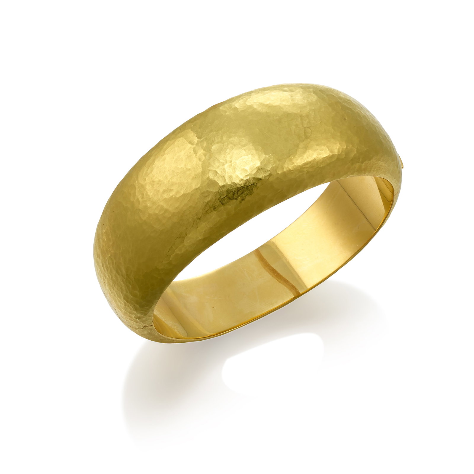 VENDORAFA: AN 18K GOLD BRACELET: VENDORAFA: AN 18K GOLD BRACELET A hinged bangle of a domed and hammered gold design; with Italian registered trademark; inner circumference 6 3/4 in.; width at center 1 in. Footnotes: OVERALL