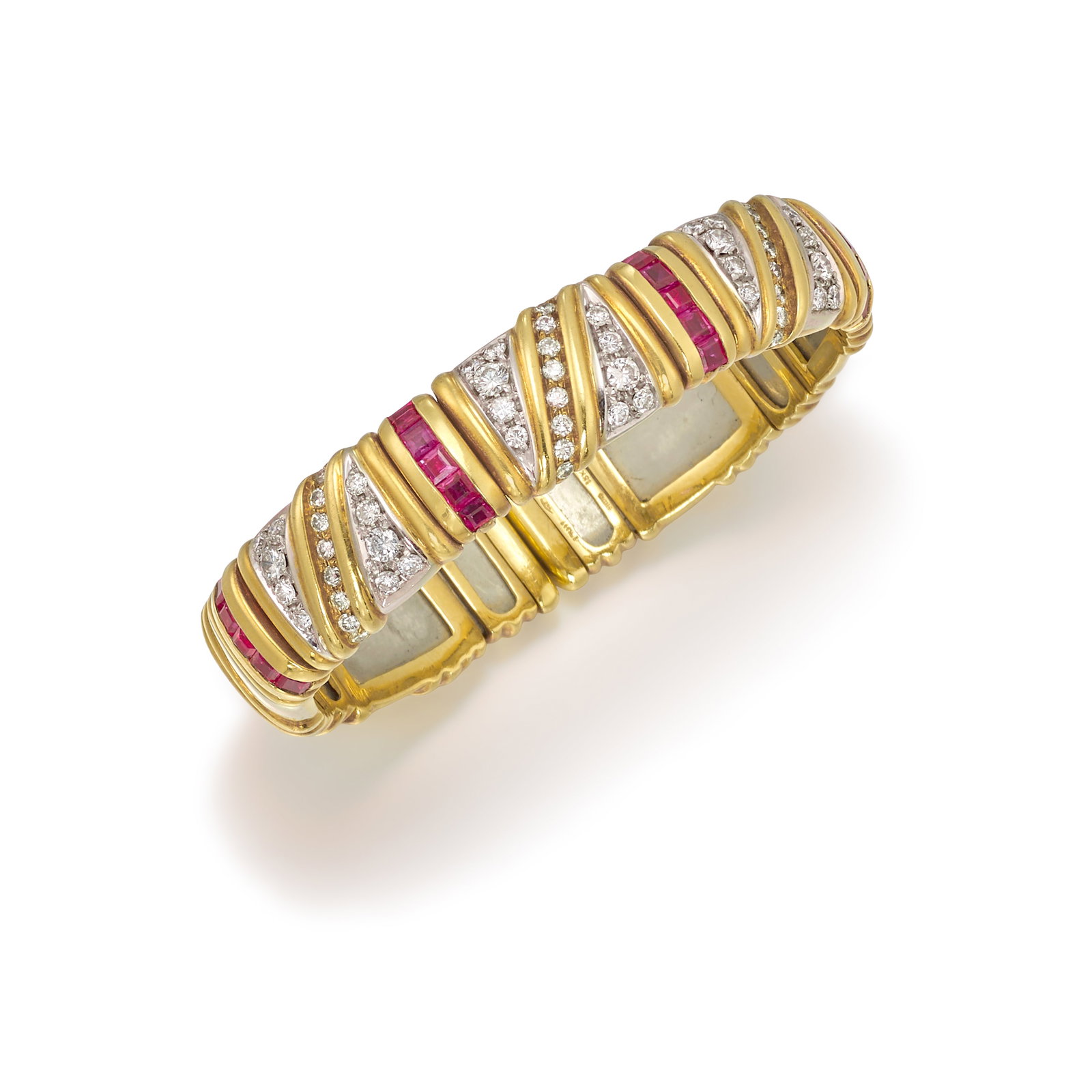 AN 18K BICOLOR GOLD, DIAMOND AND RUBY BRACELET: AN 18K BICOLOR GOLD, DIAMOND AND RUBY BRACELET A flexible cuff of geometric-inspired design, alternating bands of square-cut rubies and pavé-set round brilliant-cut diamonds; with Italian registe