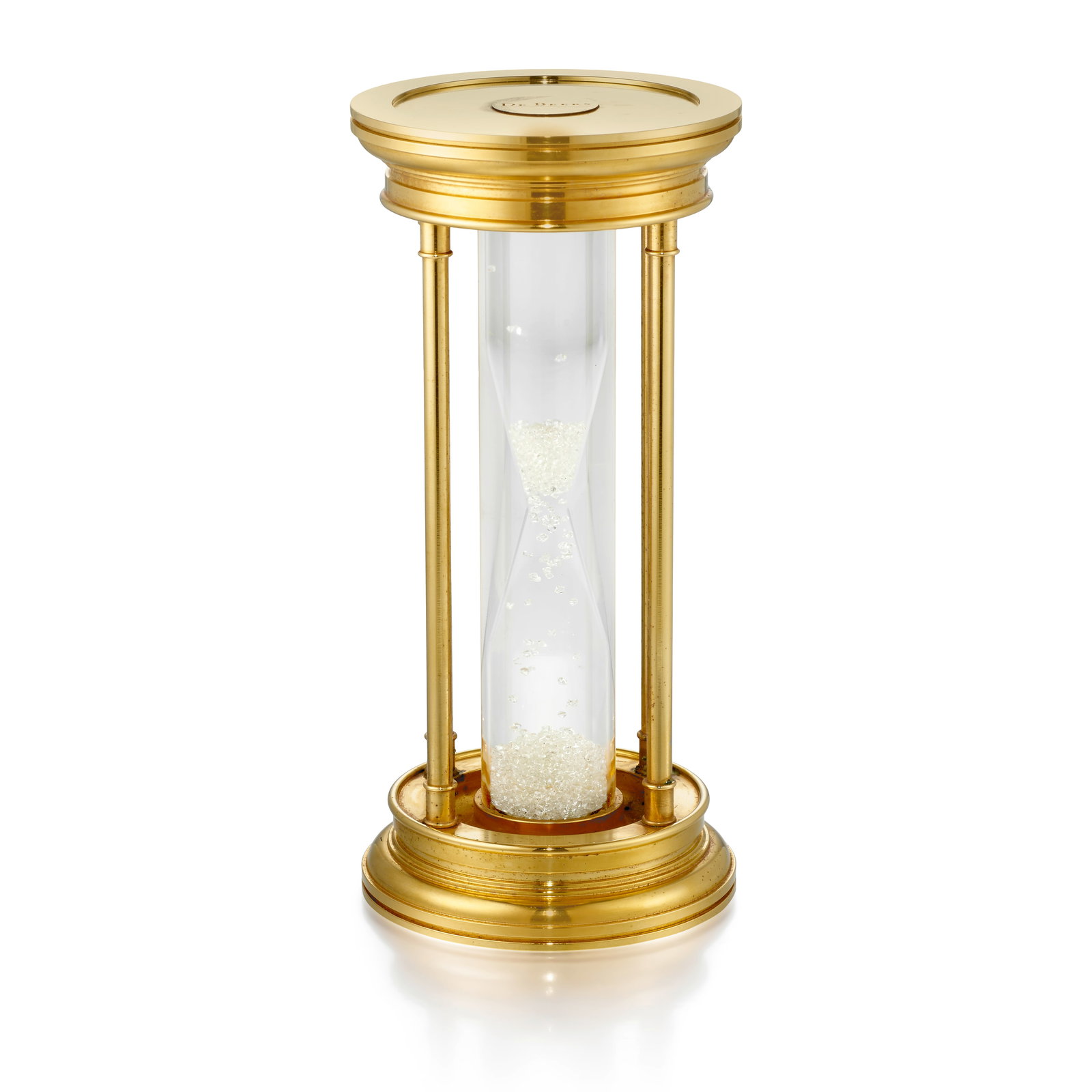 DE BEERS: A DIAMOND HOURGLASS: DE BEERS: A DIAMOND HOURGLASS Composed of a gold-plated frame, with floating rough diamonds inside; each top of hourglass signed De Beers; measures 5 7/8 (H) x 2 3/4 (W) in.; accompanied by signed and