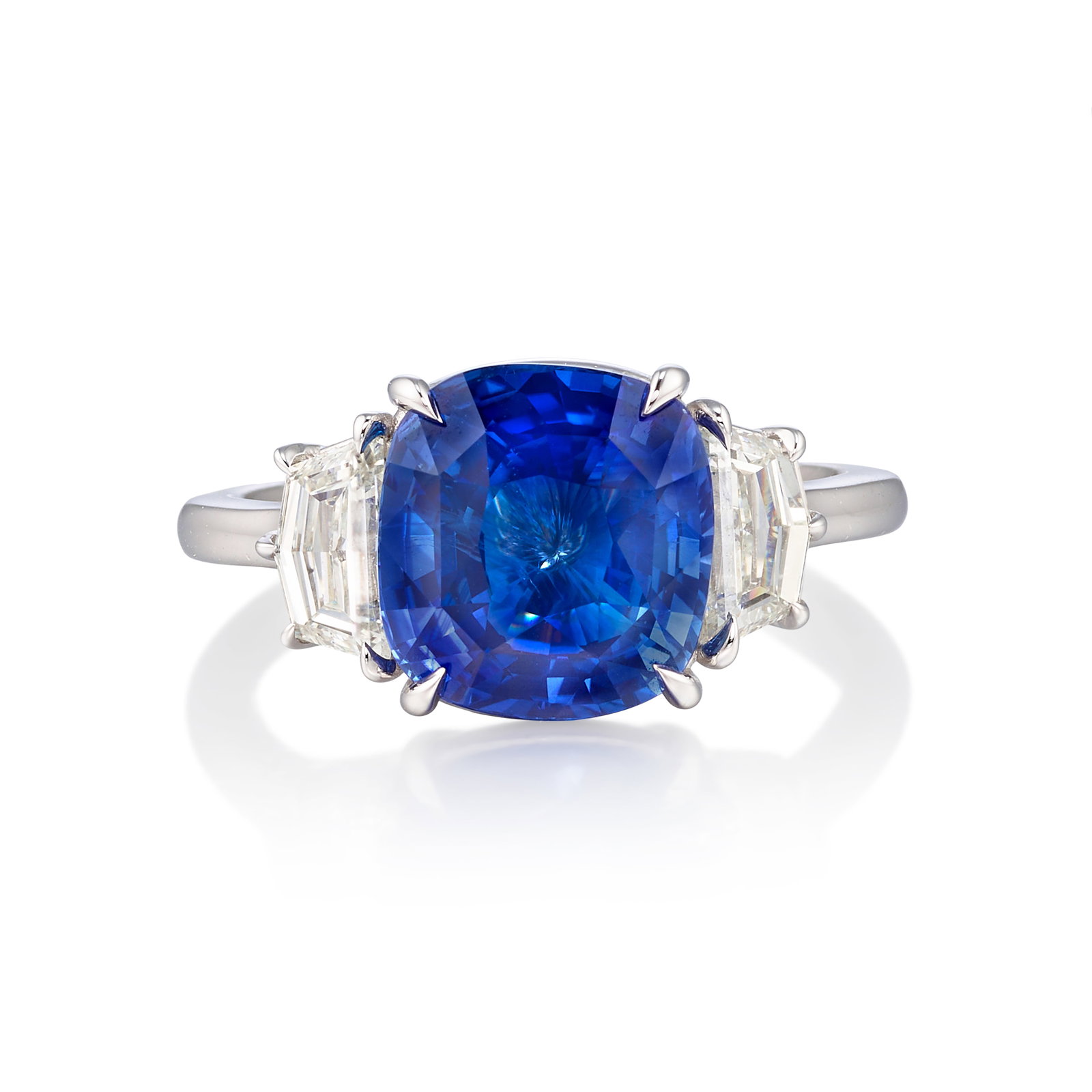 A SAPPHIRE AND DIAMOND RING: A SAPPHIRE AND DIAMOND RING Centering a cushion-shaped sapphire, flanked by tapered pentagon-shaped diamonds; estimated sapphire weight 4.70 carats; estimated total diamond weight 0.85 carat; mounted