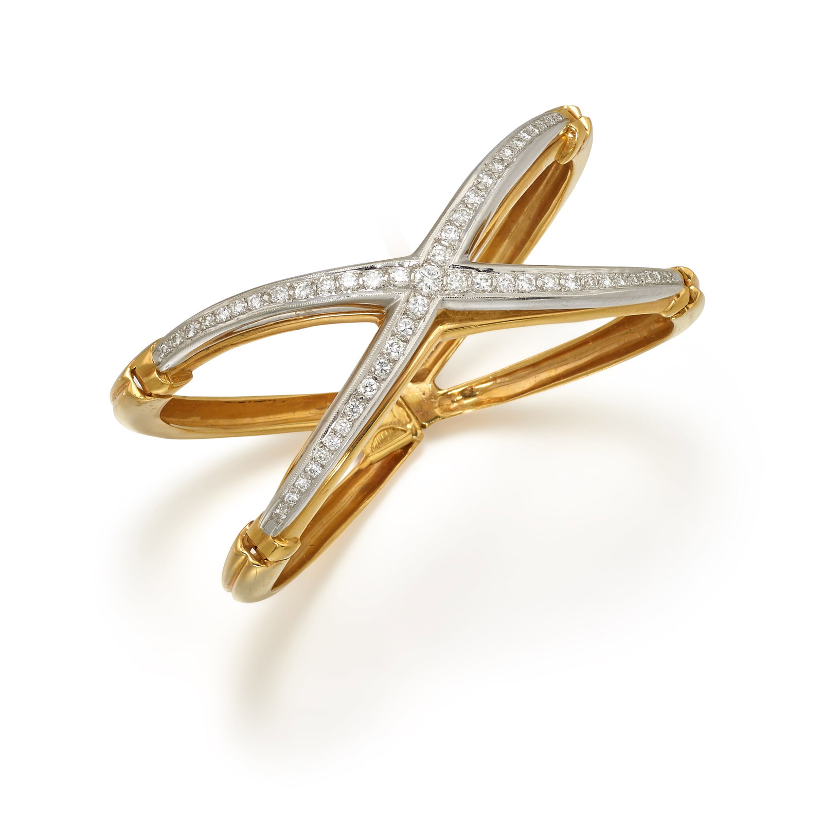 A BICOLOR GOLD AND DIAMOND BRACELET: A BICOLOR GOLD AND DIAMOND BRACELET A hinged bangle of white and yellow gold, the center 'X' design accented with round brilliant-cut diamonds; estimated total diamond weight 2.55 carats; fabricated i