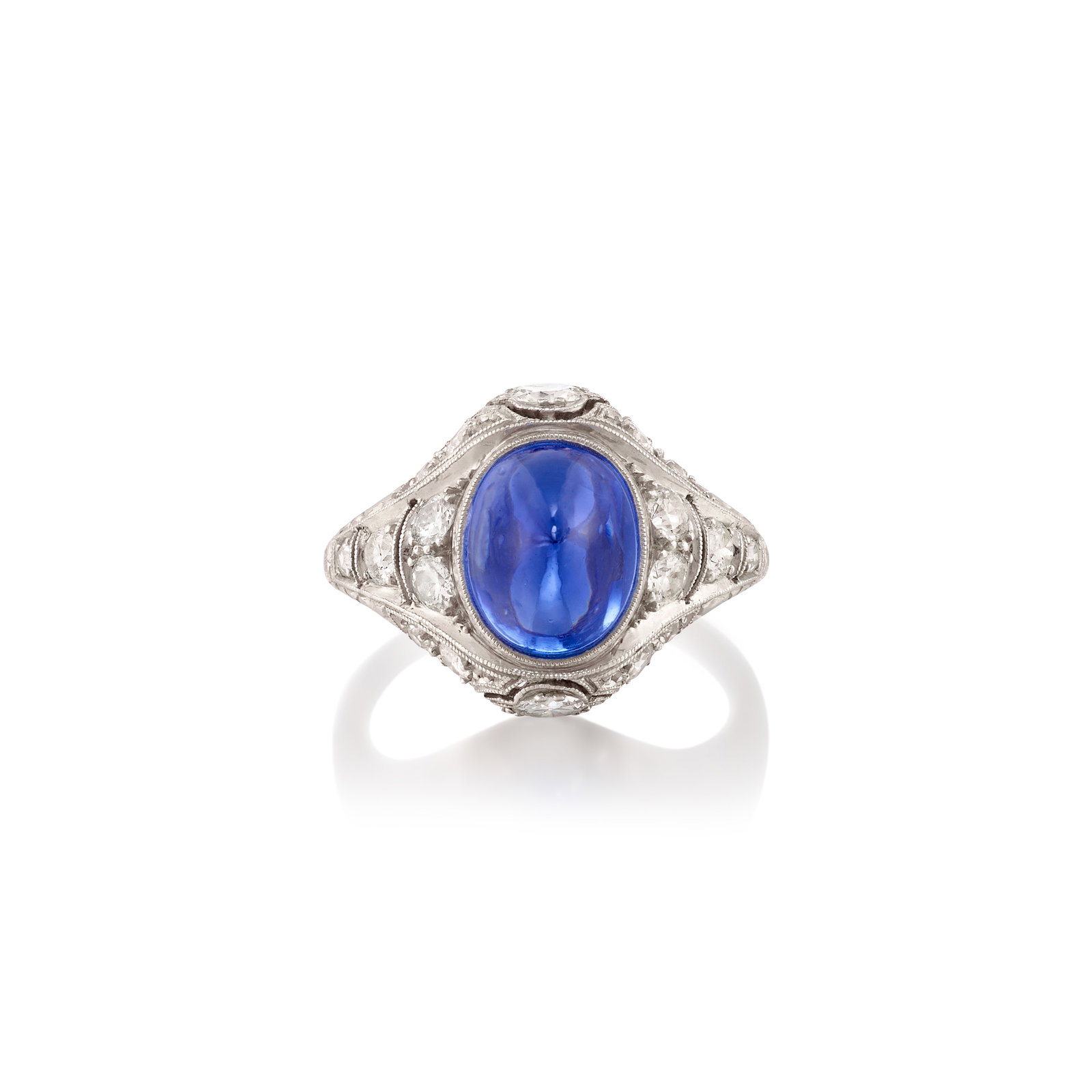 A SAPPHIRE AND DIAMOND RING, CIRCA 1915: A SAPPHIRE AND DIAMOND RING, CIRCA 1915 Centering an oval-shaped, sugarloaf cabochon sapphire, in an openwork mounting accented with old European and single-cut diamonds; estimated sapphire weight