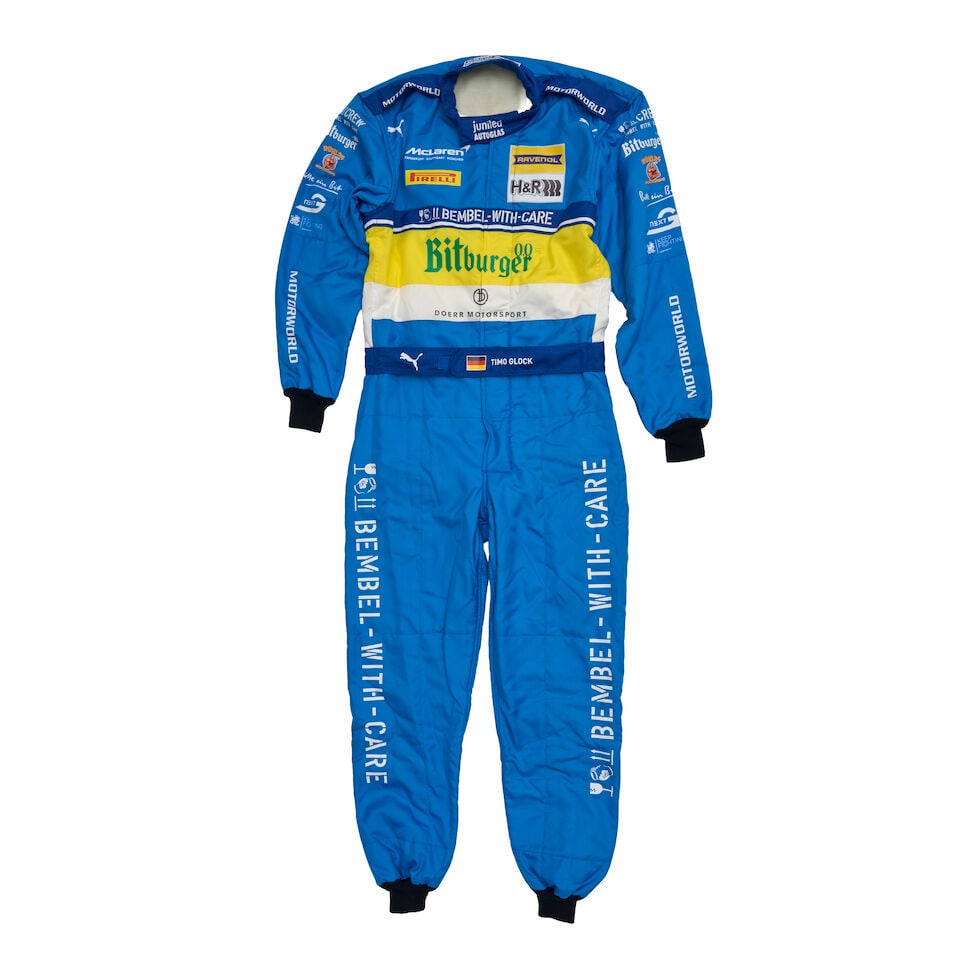 Timo Glock's 24 hour Nurburgring 2026 'Benneton inspired F1 livery' tribute overalls,: Timo Glock's 24 hour Nurburgring 2026 'Benneton inspired F1 livery' tribute overalls, in blue, yellow and white design, inspired by the Benneton F1 car driven by Michael Schumacher, with sponsors