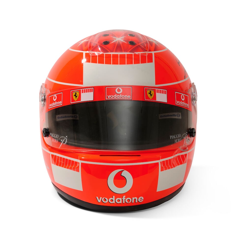 A Michael Schumacher Ferrari F1 2005 'mechanics' helmet, specially commissioned by Schumacher fo...: A Michael Schumacher Ferrari F1 2005 'mechanics' helmet, specially commissioned by Schumacher for the team, commissioned in a limited number of 50 for team members, in red, with Schumacher design,