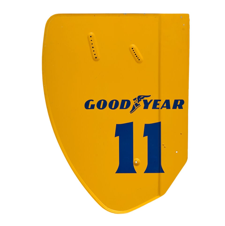 A 1989 Lotus Camel F1 rear wing end plate, believed from Nelson Piquet's car,: A 1989 Lotus Camel F1 rear wing end plate, believed from Nelson Piquet's car, painted yellow with Goodyear logo and No11, reverse black, 69 x 51cm. For further information on this lot please visit
