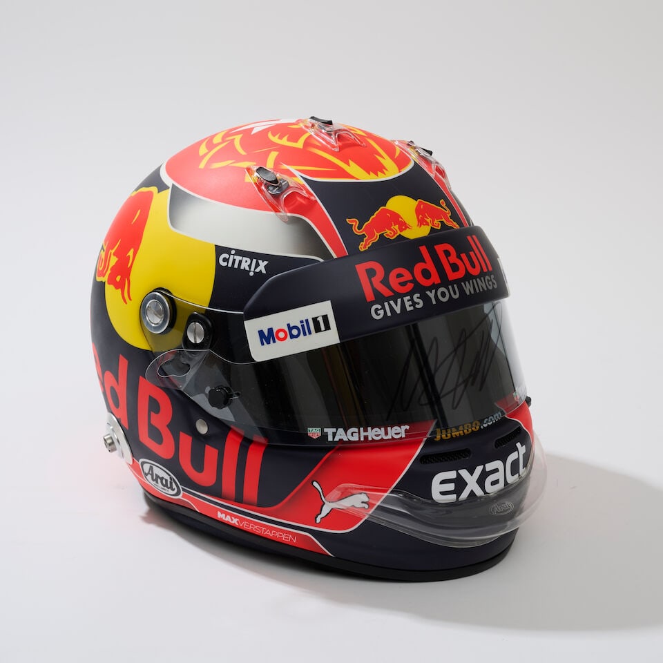 An official Max Verstappen's Red Bull Racing 2017 marketing helmet, with signed visor tear-off,: An official Max Verstappen's Red Bull Racing 2017 marketing helmet, with signed visor tear-off, painted by Jens Munser, on an Arai GP6 numbered MV-M-07/17, from a limited run believed used during the