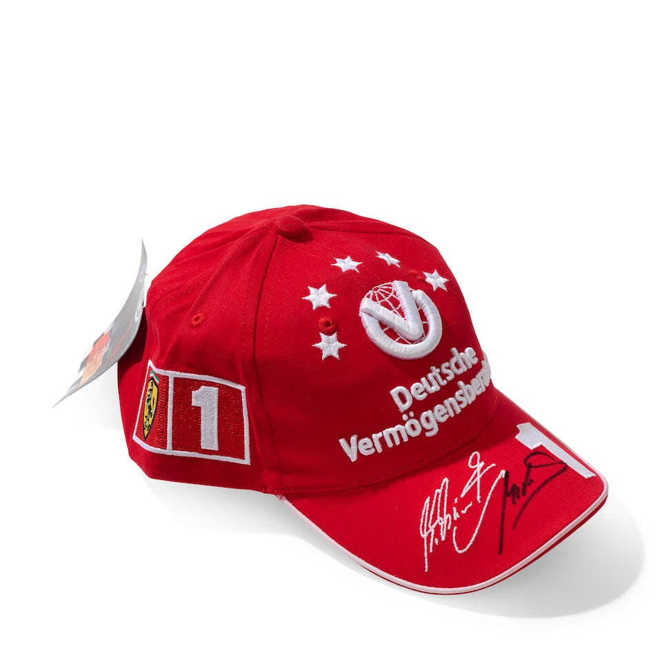 A Scuderia Ferrari Michael Schumacher 2003 cap signed by Mick Schumacher,: A Scuderia Ferrari Michael Schumacher 2003 cap signed by Mick Schumacher, believed size junior, with sponsors logos, signed to the peak in black marker by Mick Schumacher. For further information on