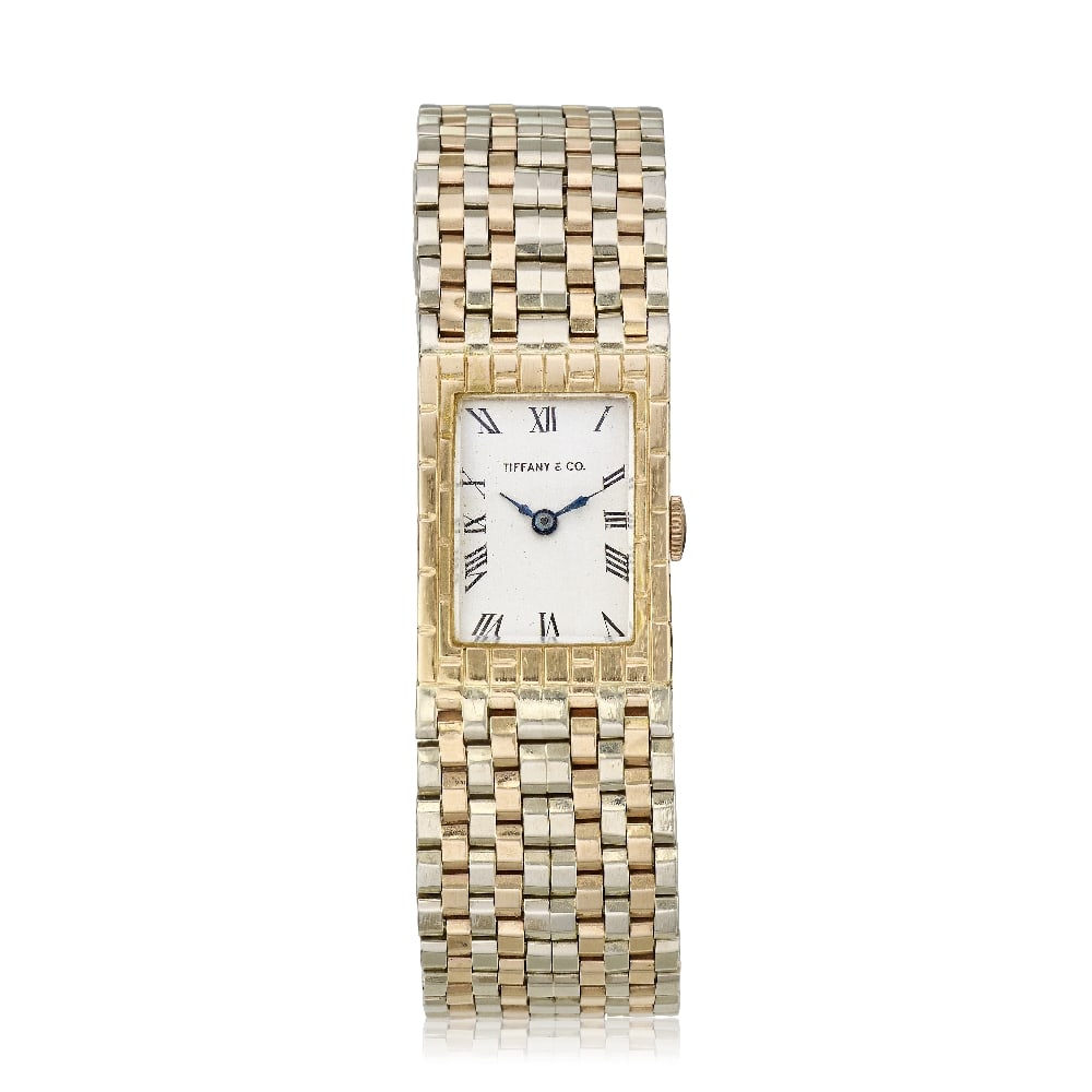 A 14K gold manual wind bracelet watch bearing the signature Tiffany & Co. Circa 1960: A 14K gold manual wind bracelet watch bearing the signature Tiffany & Co. Date: Circa 1960 Movement: 17-jewel manual wind Dial: Silvered, black Roman numeral hour markers, blued steel pointed baton ha