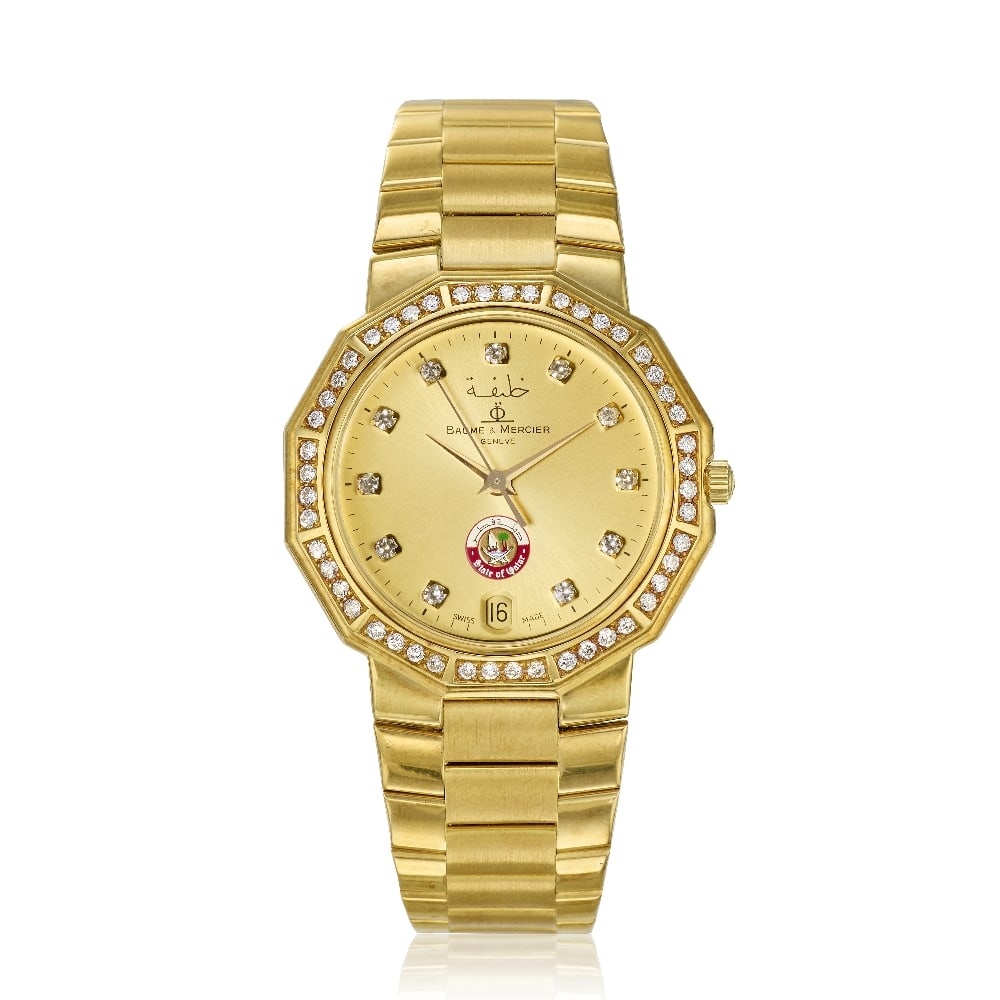 Baume & Mercier. An 18K gold diamond set quartz calendar bracelet watch with 'State of Qatar' di...: Baume & Mercier. An 18K gold diamond set quartz calendar bracelet watch with 'State of Qatar' dial Model: Riviera Reference: 87012.1 Date: Circa 1980 Movement: Jewelled quartz Dial: Champagne, applied