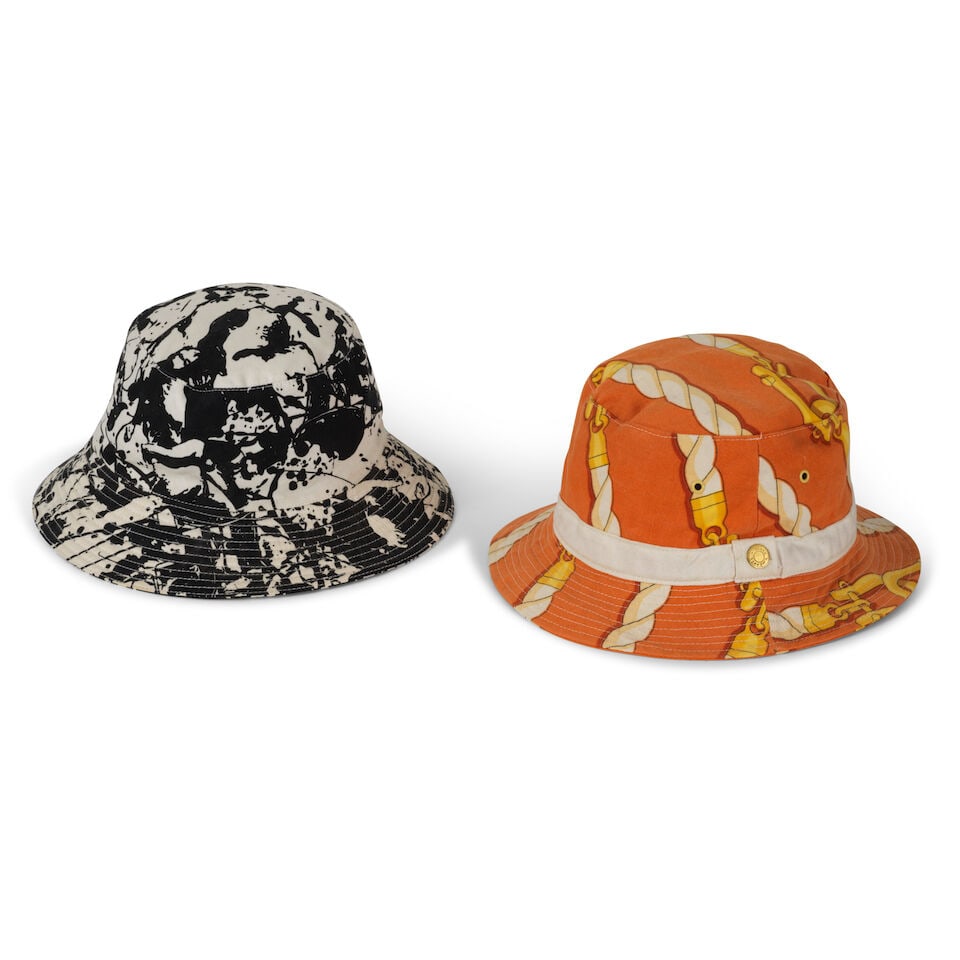 Hermès Paris. Deux bobs en coton imprimé. Hermès Paris. Two printed cotton bucket...: Hermès Paris. Deux bobs en coton imprimé. Hermès Paris. Two printed cotton bucket hats. Taille indiquée sur le bob noir: 57. Size indicated on the black bucket hat: