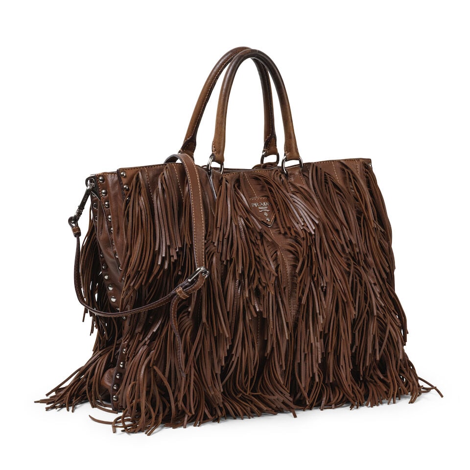 Prada. Sac Noce en cuir chocolat à fringes. Prada. Noce bag in chocolate leather with fringes.: Prada. Sac Noce en cuir chocolat à fringes. Prada. Noce bag in chocolate leather with fringes. Anse d'épaule réglable. Adjustable shoulder strap. 37 x 30 x 11 cm. Footnotes: Patine sur