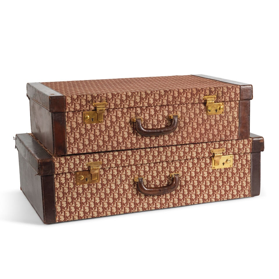 Christian Dior, circa 1975. Deux valises en toile Oblique rouge. Christian Dior, circa 1975. Two...: Christian Dior, circa 1975. Deux valises en toile Oblique rouge. Christian Dior, circa 1975. Two suitcases in red Oblique canvas. Petite valise/ Small suitcase : 69,5 x 44 x 18,5 cm. Grande