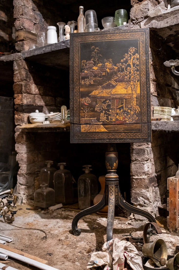 A George III black Japanned tripod table Early 19th century: A George III black Japanned tripod table Early 19th century The rectangular tilt-top decorated with Oriental figures playing games amongst buildings and a large pine tree on a turned support and gilt