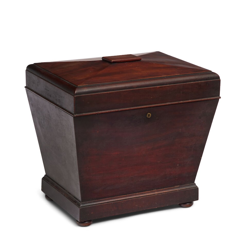 A George III mahogany sarcophagus shaped cellarette Third quarter 18th century: A George III mahogany sarcophagus shaped cellarette Third quarter 18th century Of small proportions, the hinged top enclosing a divided interior with tapering sides on turned squat bun feet, 46cm