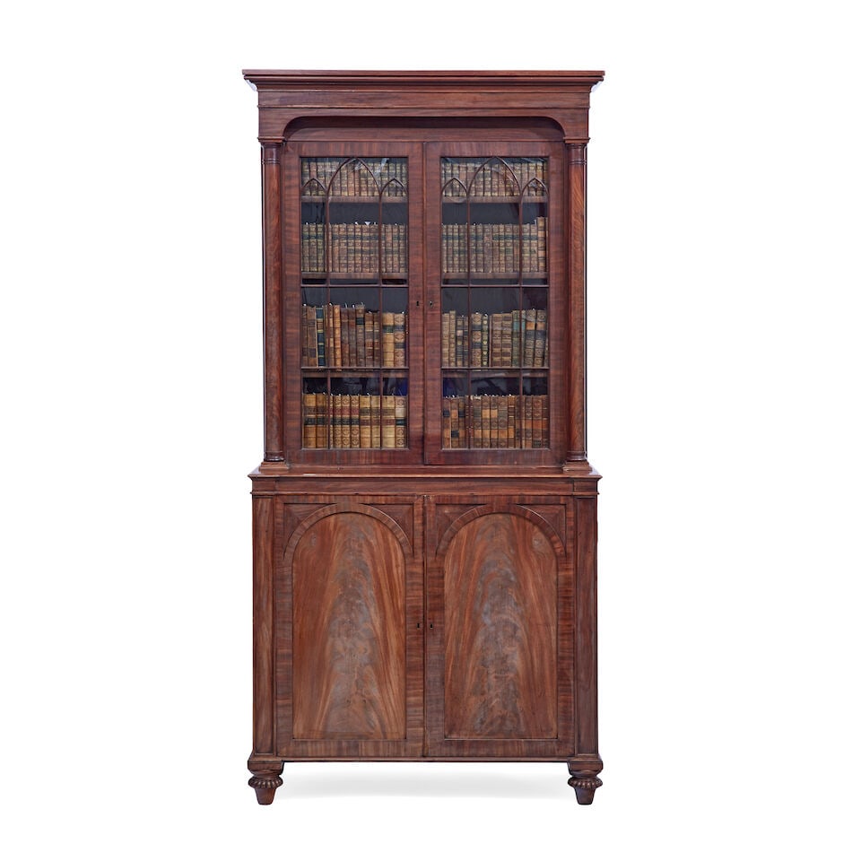 A William IV mahogany bookcase Early 19th century, attributable to Gillows: A William IV mahogany bookcase Early 19th century, attributable to Gillows The ogee moulded cornice above a pair of astragal glazed doors enclosing adjustable shelves above a pair of panelled doors en