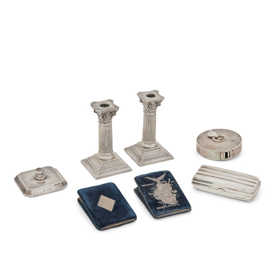 A collection of silver desk items Various makers and dates (7): A collection of silver desk items Various makers and dates Comprising a pair of Edwardian Corinthian column library candlesticks, Walker and Hall, Sheffield, 1904, 15.5cm high; a silver tape measure,