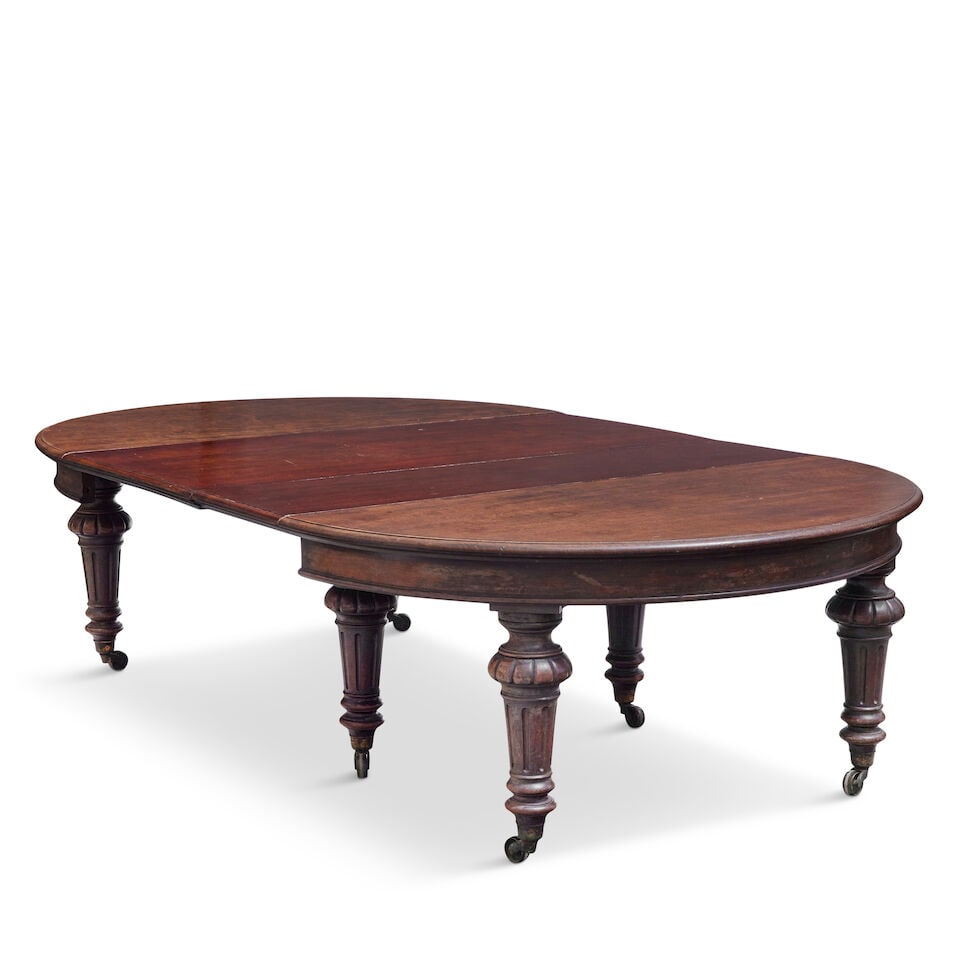 A very large Victorian mahogany extending dining tableMid-19th century: A very large Victorian mahogany extending dining table Mid-19th century With rounded ends, together with five additional leaves above a pull-out telescopic action on turned and fluted tapering legs