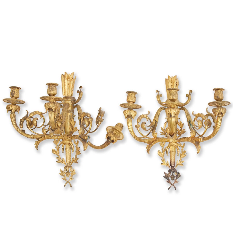A pair of French late 19th century gilt metal wall sconces In the Louis XVI style (2): A pair of French late 19th century gilt metal wall sconces In the Louis XVI style Each with three scones on acanthus clasped arms arranged around a central column in the form of quivers and arrows,