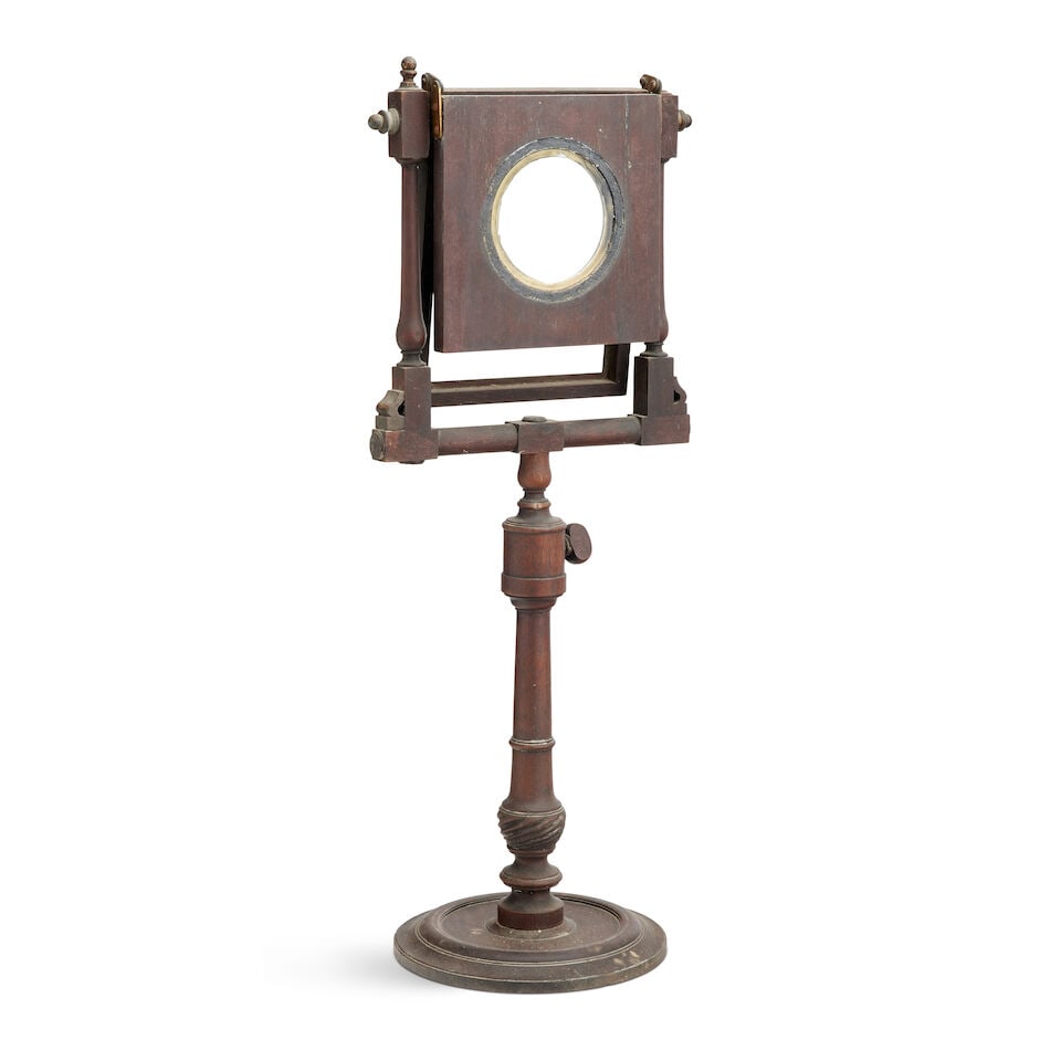 A late George III mahogany zograscope Early 19th century: A late George III mahogany zograscope Early 19th century On an adjustable turned column support and circular base, 27cm wide, 26cm deep, 64.5cm high (10 1/2in wide, 10in deep, 25in high) For further