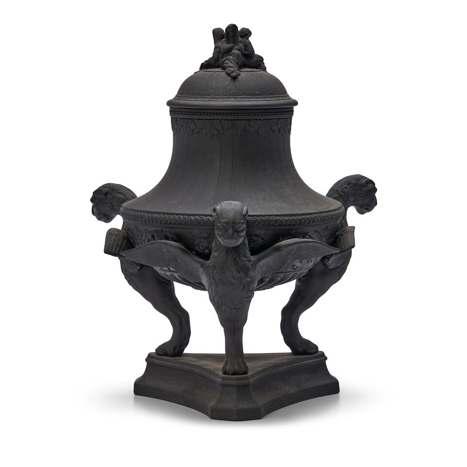 Wedgwood Black Basalt Tripod Urn and Cover, England, early 20th century,: Wedgwood Black Basalt Tripod Urn and Cover, England, early 20th century, three widow finial set to a domed and engine turned cover, the bowl with engine turning over a wide arabesque band and supporte