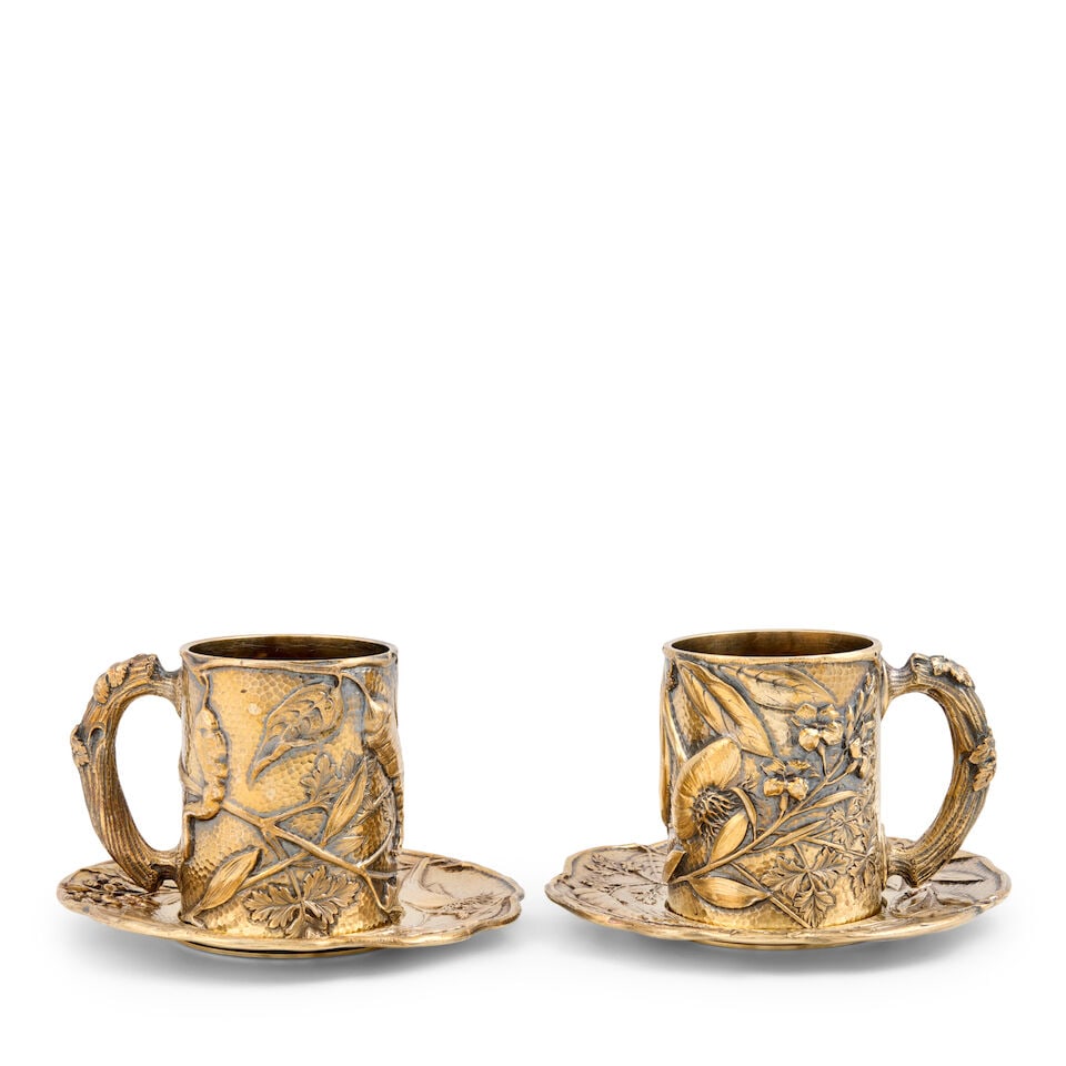 Pair of French .950 Silvergilt Cups and Saucers,: Pair of French .950 Silvergilt Cups and Saucers, Paris, late 19th/early 20th century, Georges Useldinger, maker, also marked for retailer: 'BOUDET/43Bd. Carucines/Paris,' each with various fruits, lea
