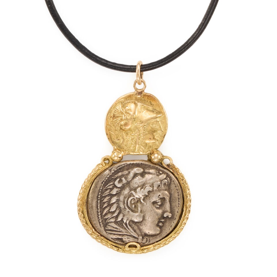 18K GOLD AND SILVER COIN PENDANT NECKLACE: 18K GOLD AND SILVER COIN PENDANT NECKLACE • Silver coin framed in 18k yellow gold • Black leather cord • Length 31 1/2 in., pendant measures 1 7/8 x 1 1/4 in. • Estimated