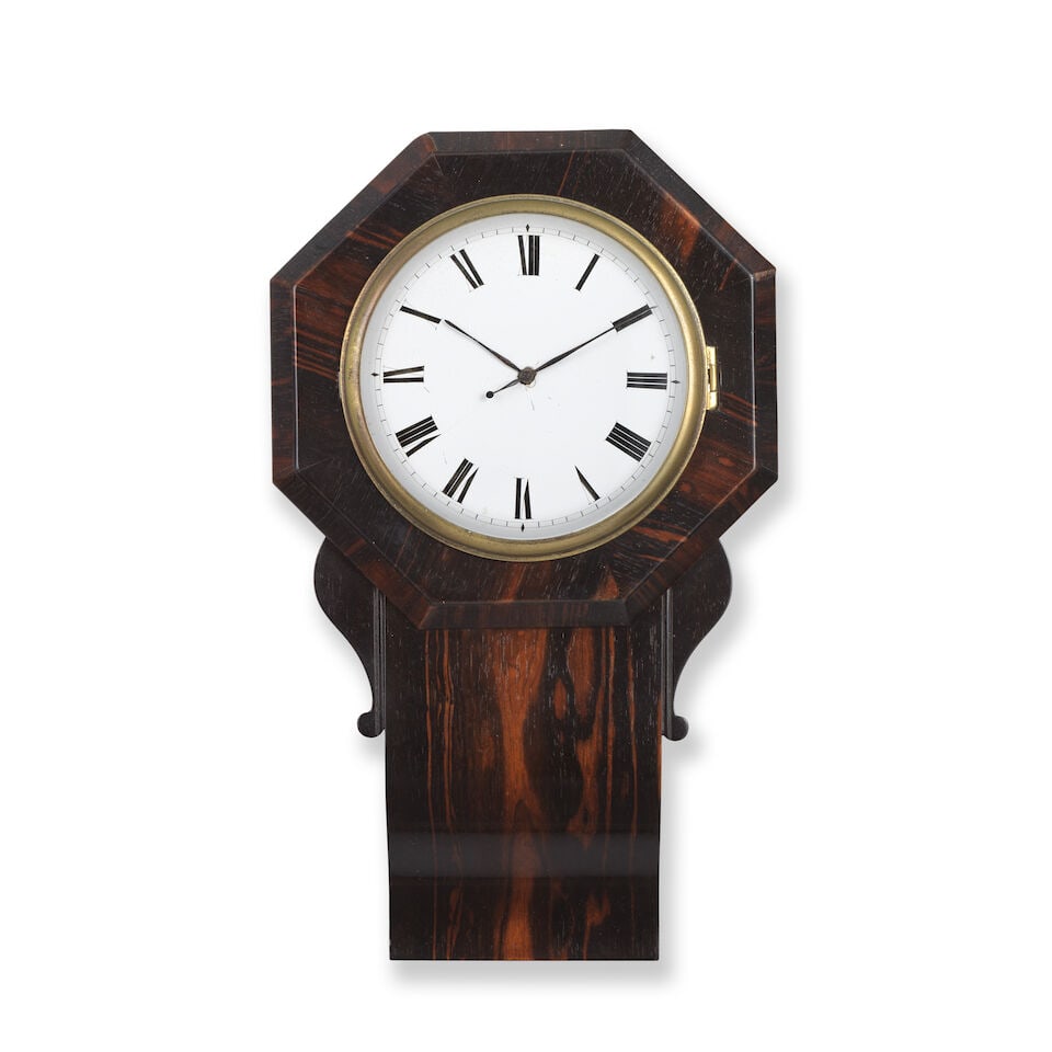 A Regency coromandel cased miniature Sudan type drop dial clock: A Regency coromandel cased miniature Sudan type drop dial clock The case with octagonal top with simple sides to a sloped base, the back lifting up to reveal the movement with a cast brass bezel. The 