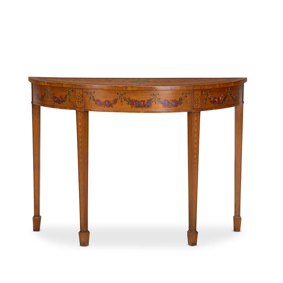 A George III and later satinwood and polychrome decorated pier tableLate 18th century and later: A George III and later satinwood and polychrome decorated pier table Late 18th century and later The demi-lune top painted with a central medallion enclosed by ribbon tied floral scrolls, with a peaco