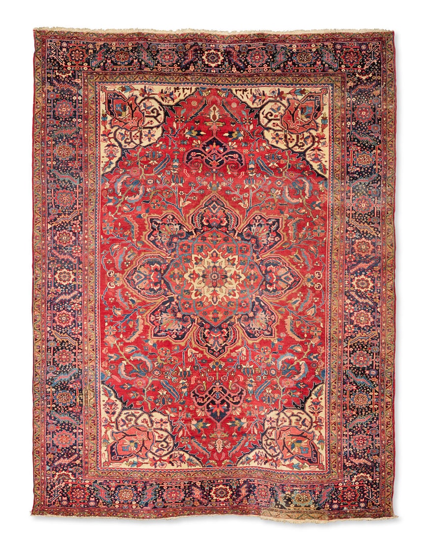 A Heriz carpet North West Persia, later cut and shut 395cm x 301cm: A Heriz carpet North West Persia, later cut and shut On typical rich madder ground, with central medallion, the whole designed with palmettes and serrated vines and spiralling tendrils, 395cm x