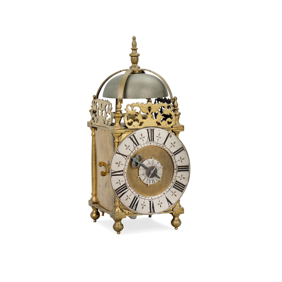 A 20th century miniature brass lantern clock with alarm: A 20th century miniature brass lantern clock with alarm The case surmounted by a central turned finial above a strapped bell, four finials and pierced frets. The 4-inch brass dial with silvered Roman 