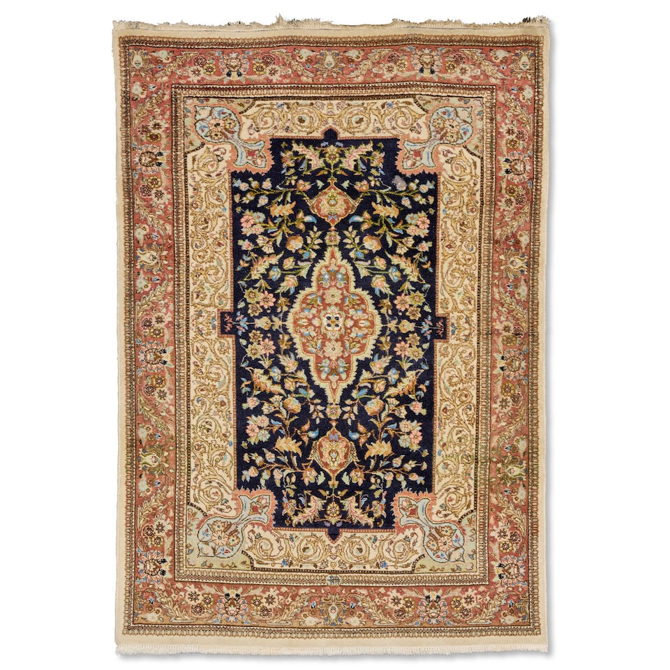 A Tabriz carpet North West Persia, 210cm x 148cm: A Tabriz carpet North West Persia, With central slender medallion, the central field with an abundance of flower-heads and palmettes, enclosed by ivory border and madder/brown border, 210cm x