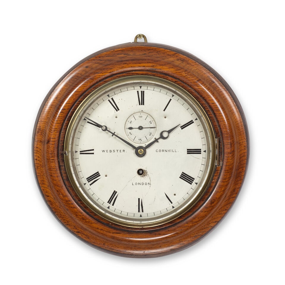 A late 19th century wall clock By Webster, Cornhill: A late 19th century wall clock By Webster, Cornhill Set in a circular oak moulded surround, with brass bezel, and a silvered Roman dial with subsidiary seconds dial and crescent hands. 36cms (14.5ins)