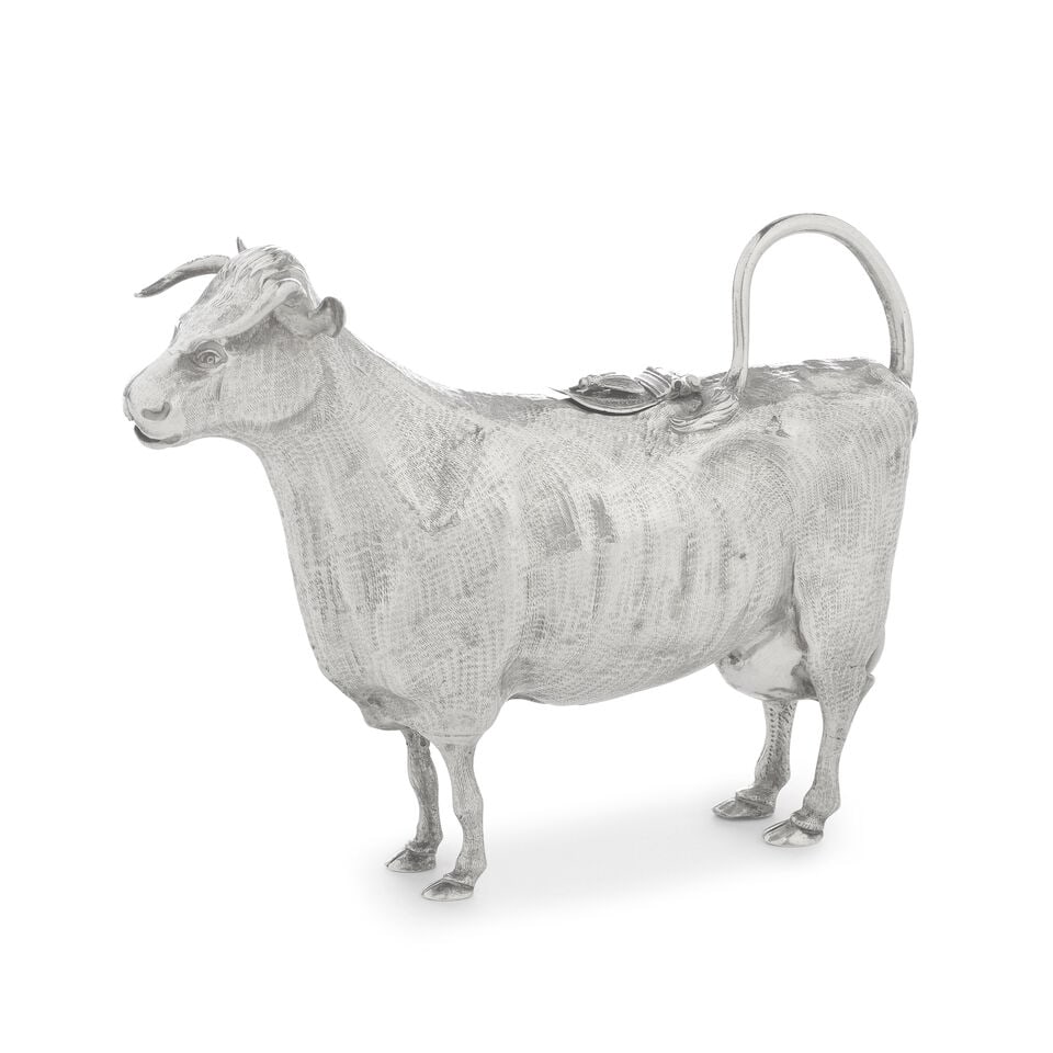 A silver cow creamer unmarked: A silver cow creamer unmarked Of conventional form, with textured body, the hinged foliate cover with applied fly, height 13cm, length 16cm, weight 6oz. For further information on this lot please