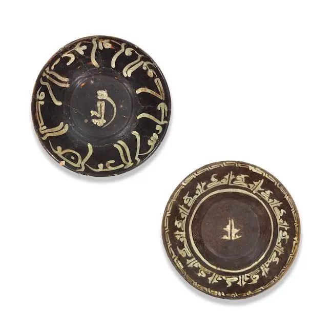 Two Samanid slip-painted pottery bowls Persia, 10th Century(2): Two Samanid slip-painted pottery bowls Persia, 10th Century each of conical form on a short foot, decorated in cream and aubergine slip, the first with inscriptions in kufic; the second with a pseudo-