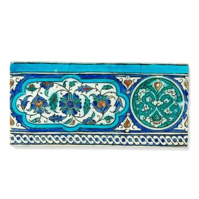 An Ottoman pottery tile Turkey, Iznik or Diyarbakir, 16th Century: An Ottoman pottery tile Turkey, Iznik or Diyarbakir, 16th Century of rectangular form, decorated underglaze in raised-red, cobalt blue, turquoise, green and black outline on a white ground with a cart
