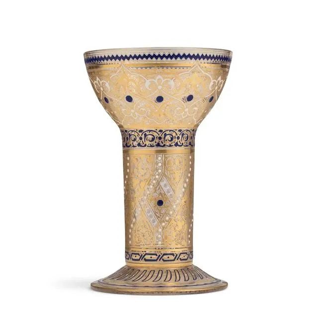 A Lobmeyr enamelled glass goblet for the Islamic market Austria, circa 1878: A Lobmeyr enamelled glass goblet for the Islamic market Austria, circa 1878 of cylindrical form rising to cup on a splayed foot, decorated in blue and white enamel and gilt with bands filled with flor