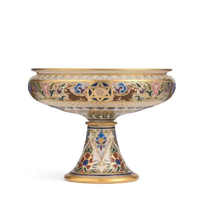 A Lobmeyr enamelled glass tazza for the Islamic market Austria, late 19th Century: A Lobmeyr enamelled glass tazza for the Islamic market Austria, late 19th Century of shallow rounded form on a tall splayed foot, decorated in polychrome enamel and gilt with alternating hare and flor
