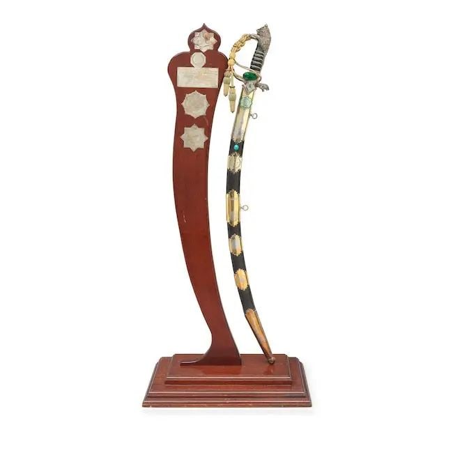 An unusual gem-set enamelled silver-gilt hilted steel ceremonial sword commemorating the family ...: An unusual gem-set enamelled silver-gilt hilted steel ceremonial sword commemorating the family of the Shaykhs of the Al al-'Abid, the leaders of the Albu Diraj clan in Iraq, with the names of three o